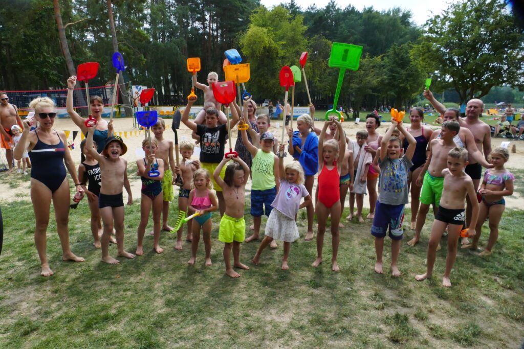 Uczestnicy konkursu budowania rzeźb piaskowych na plaży Jezior Głębokie.