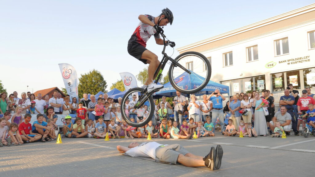 Akrobata przeskakujący na rowerze przez leżącego człowieka
